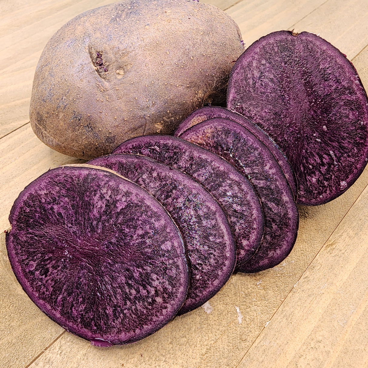 Organic Purple Majesty potato seed, round mid-season variety from SeedsNow-Potatoes, shown as purple-skinned seed potatoes.