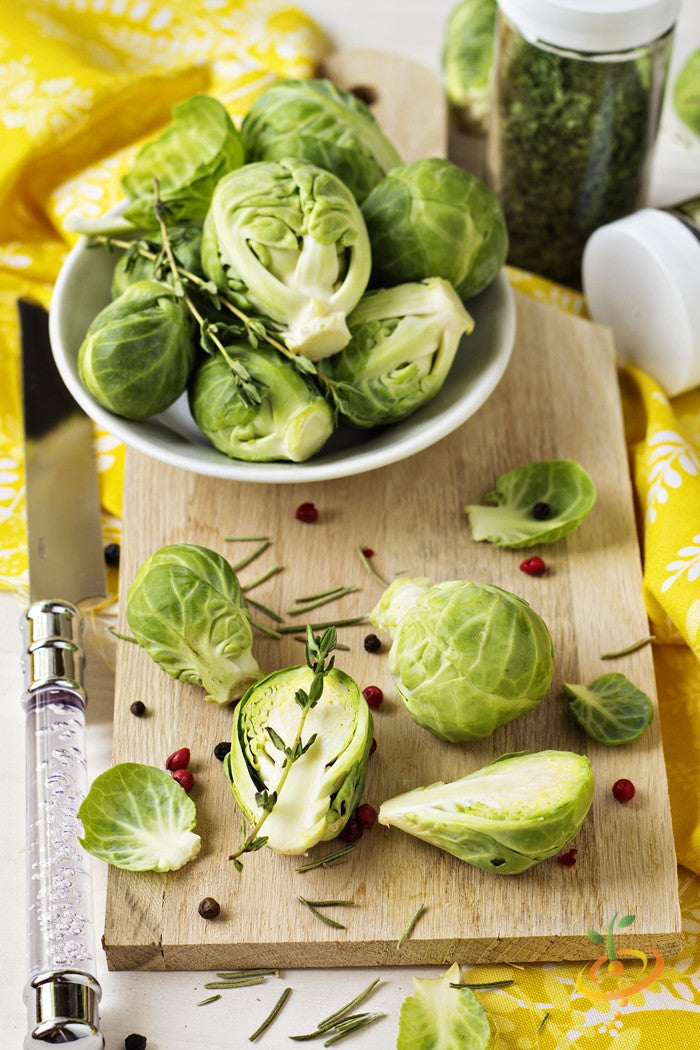 Fresh Brussels sprouts grown from SeedsNow Catskill seeds, showcasing green sprouts with leafy stems on a garden background.