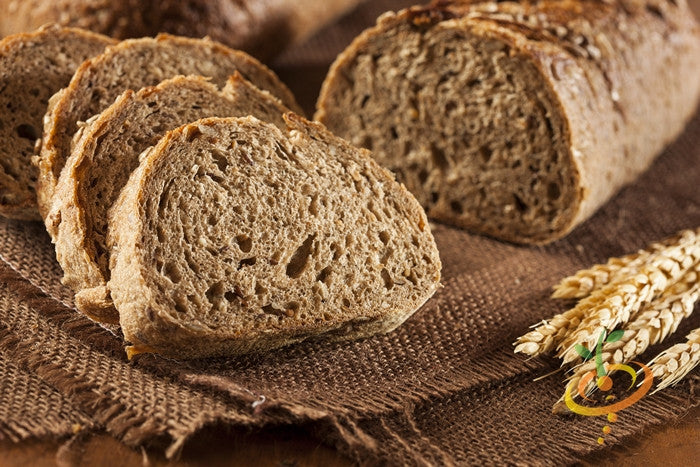 Sliced hard red wheat bread on burlap with wheat seeds.