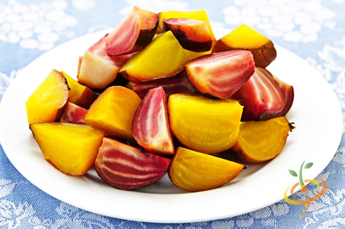 Assorted colorful beet - Detroit seeds sliced on a white plate showing golden and red-striped roots