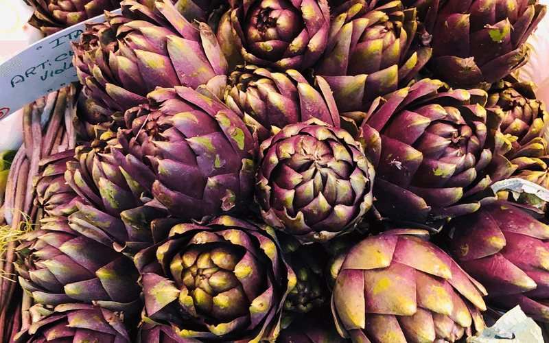 Violet Star artichoke seeds from SeedsNow, showing a close-up of vibrant green and purple artichoke seed packets.
